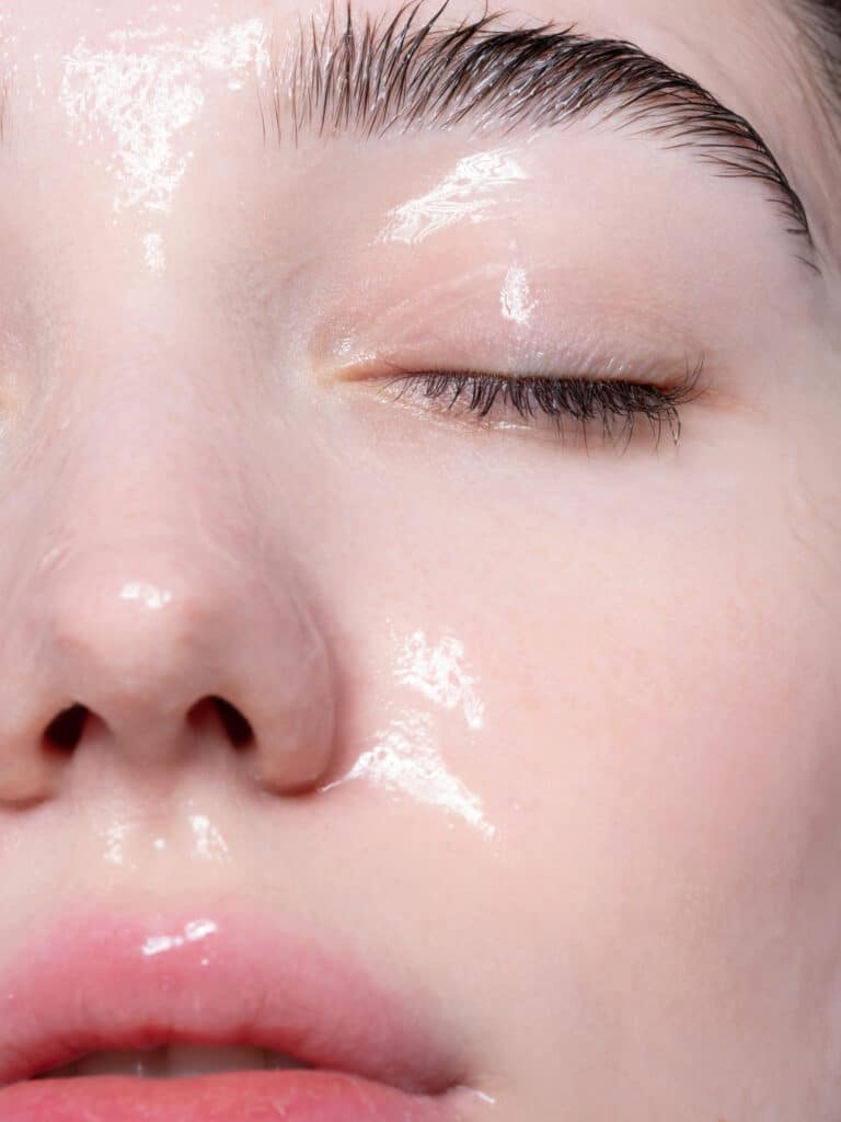 Beautiful young woman with moisturizing gel on her face